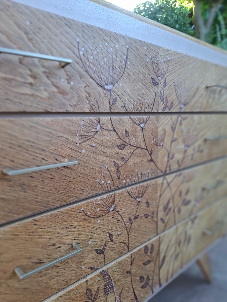 Tiroir en bois avec motifs floraux gravés sur un meuble.