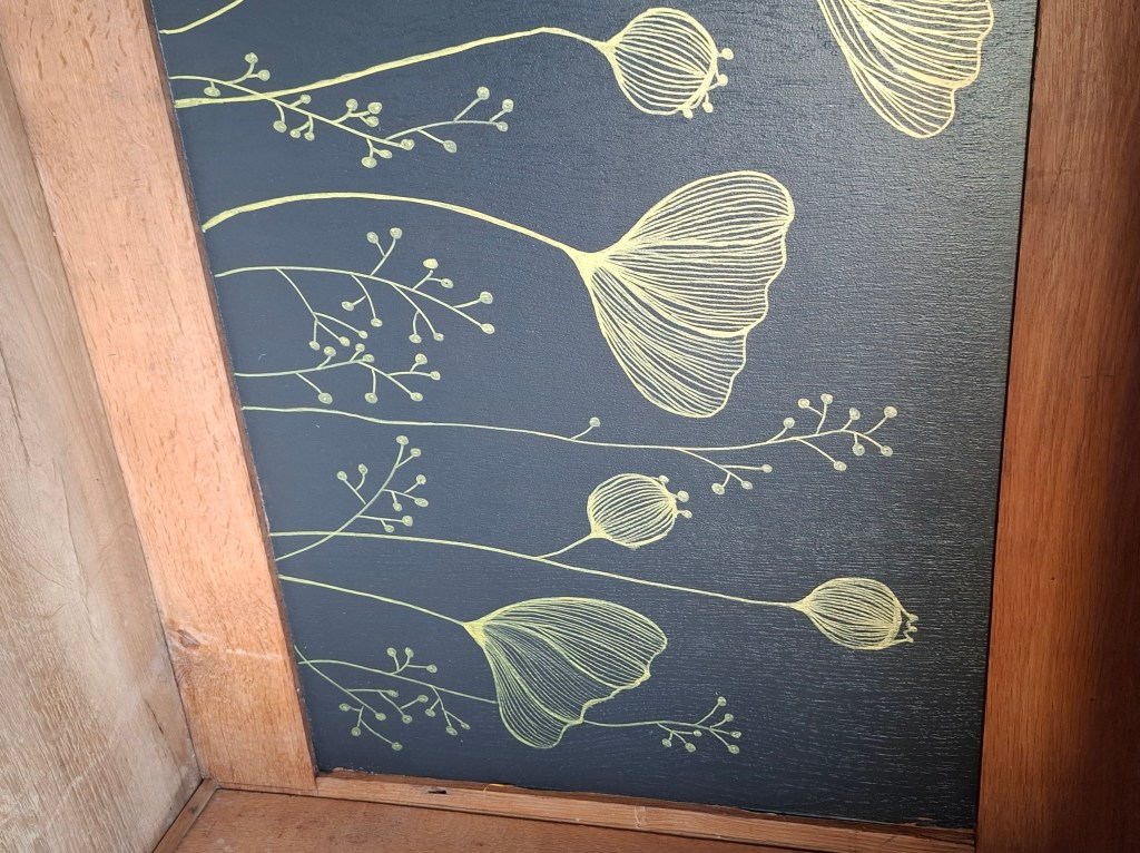 Motif floral minimaliste en jaune clair sur fond noir, avec des fleurs et des tiges délicates.