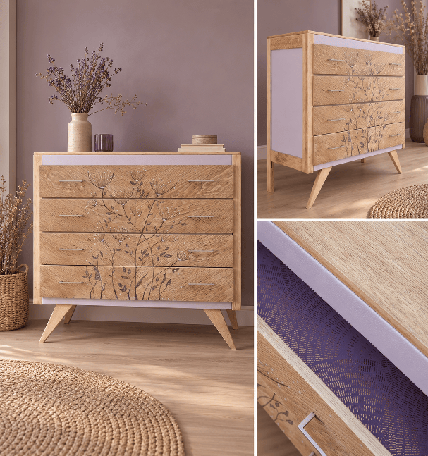Une commode en bois clair avec des dessins floraux, des tiroirs colorés en violet, et des pieds en bois, placée dans un intérieur moderne avec un vase de fleurs.