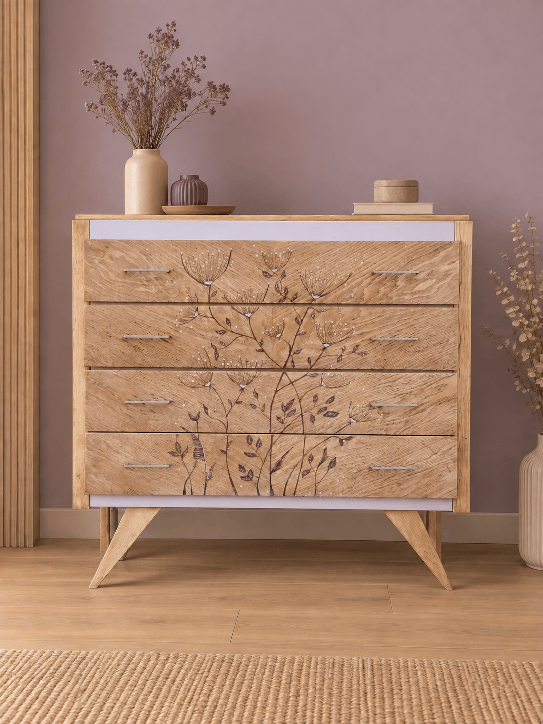 Une commode en chêne clair avec quatre tiroirs ornés de motifs floraux